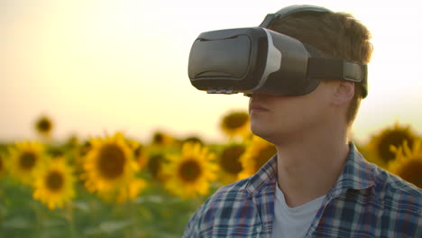 Ein-Moderner-Landwirt-Auf-Einem-Sonnenblumenfeld-Nutzt-Virtual-Reality-Brillen-Und-Gesten,-Um-Die-Bewässerungskarte-Und-Drohnen-Für-Die-Beste-Ernte-Zu-Steuern.